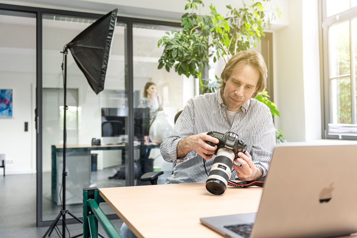 Björn Sagebiel, Designer und Fotograf mit Kamera in der Werbeagentur